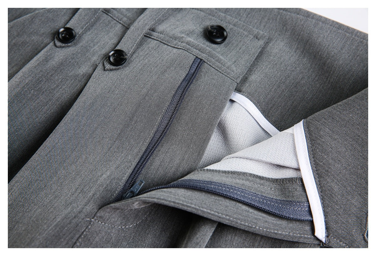 Inside close-up of gray trousers showing the zipper fly, button closure, and pale seam binding.