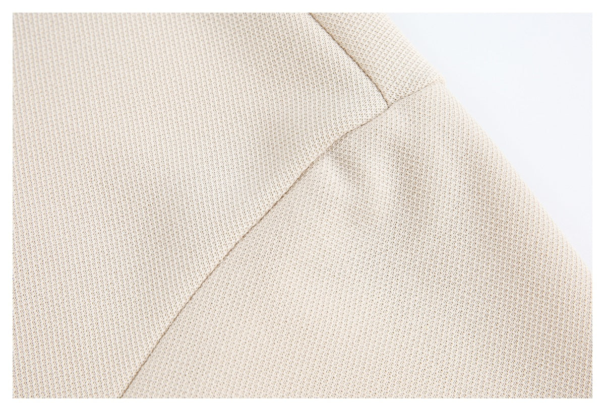 Close-up of cream-beige textured fabric and a curved seam.