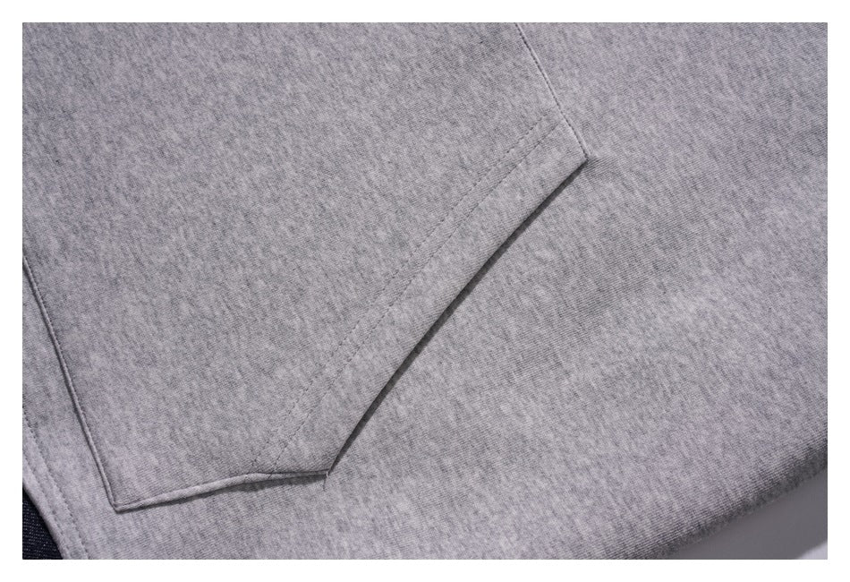 Close-up of the large kangaroo pocket and stitching on the gray hoodie front.