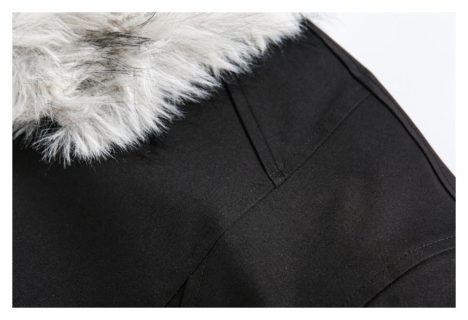 Close-up of stitched panel seams on a black jacket beneath gray-white faux-fur trim.
