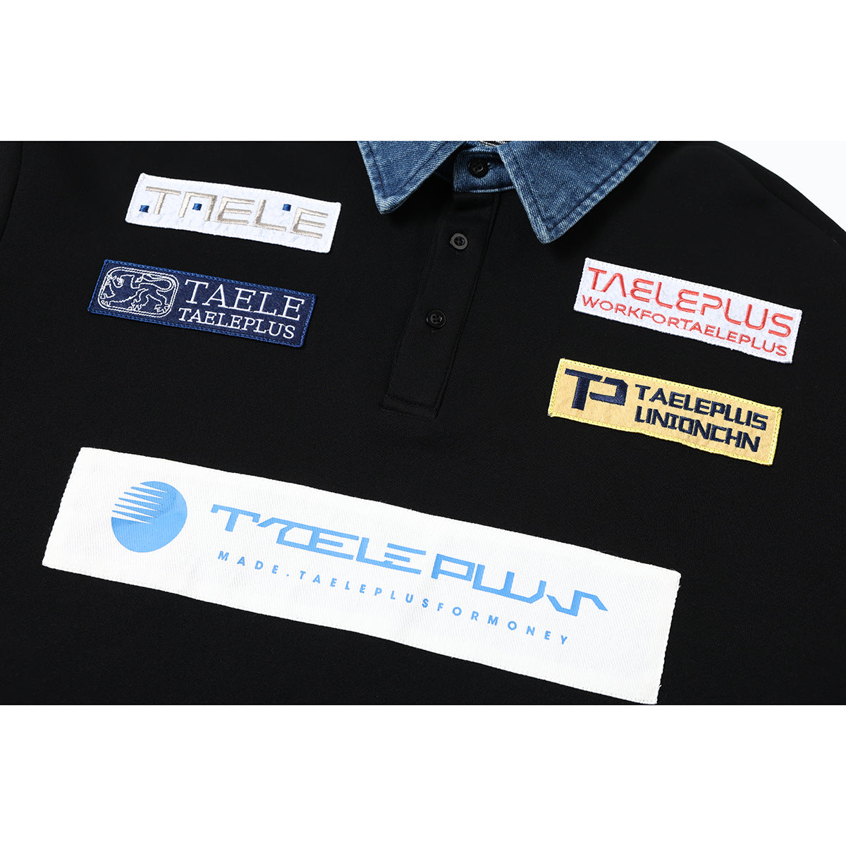Close-up of colorful sewn logo patches across the chest of a black pullover with a denim collar.