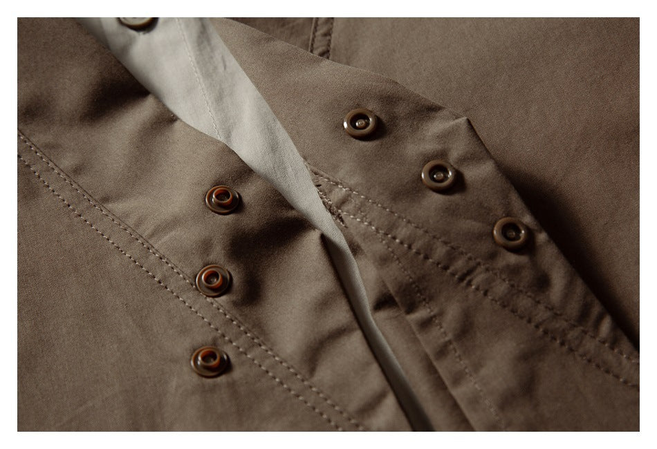 Close-up of the brown garment's overlapping placket, showing several round buttons and stitching.