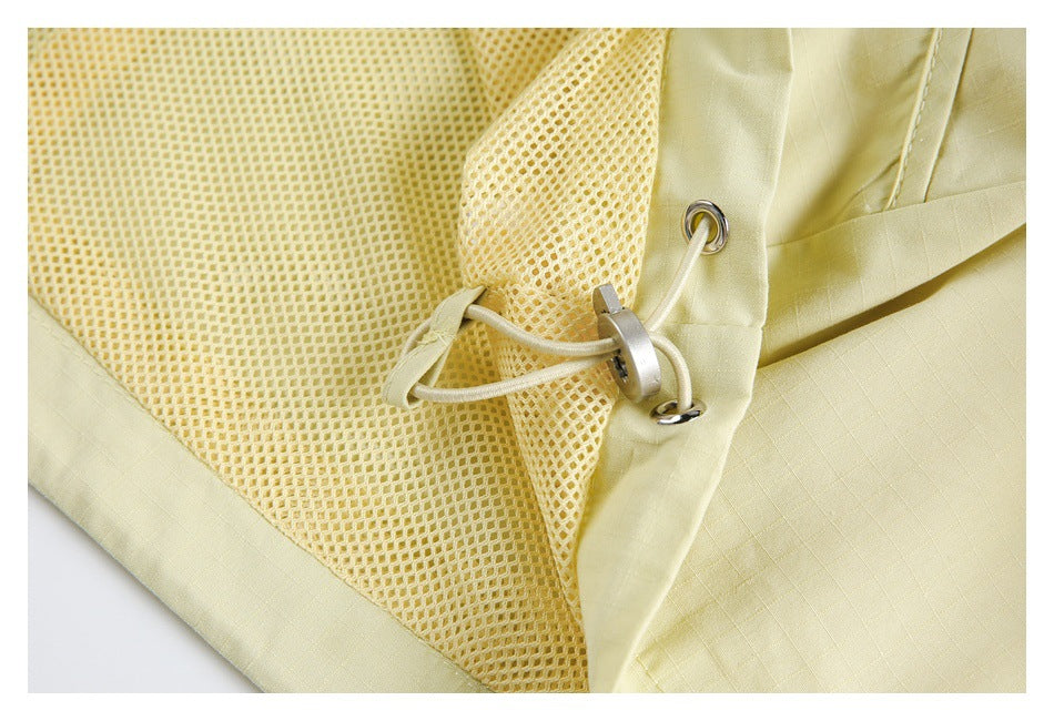 Close-up of pale yellow garment mesh lining and an adjustable drawcord with metal eyelets and toggle.