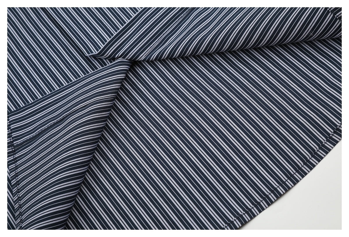 Close-up of folded navy-and-white striped shirt fabric, showing the inside and stitched hem edge.
