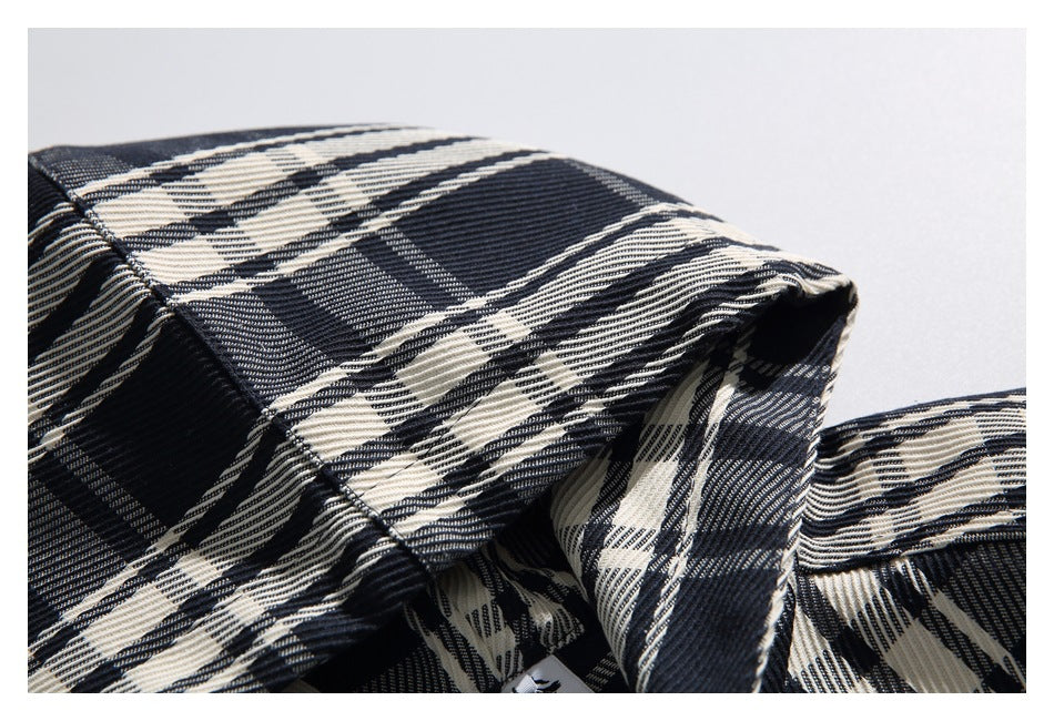 Macro view of the black, gray, and cream plaid fabric across the hood and collar.