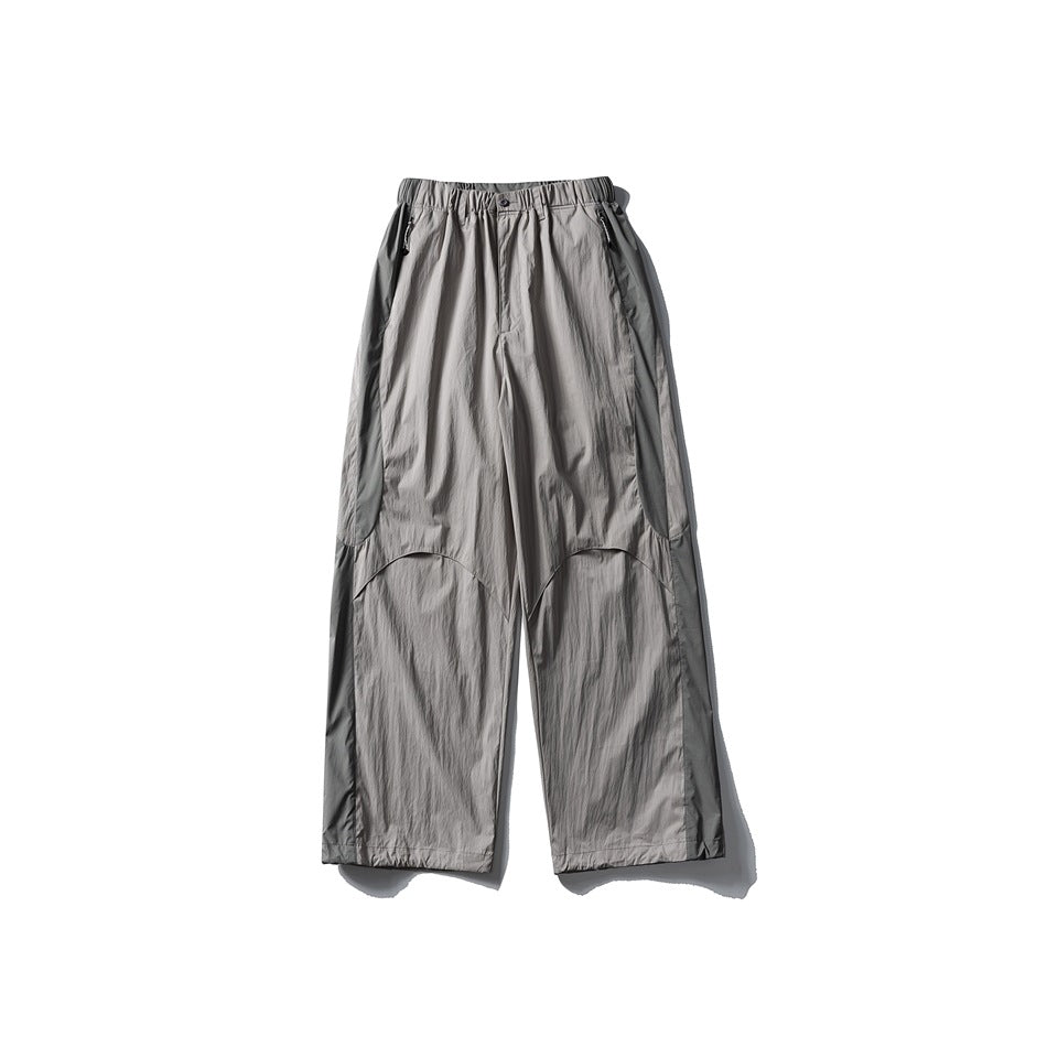 Light gray wide-leg pants with gray contrast side panels, elastic waist and zippered pockets, flat lay front view