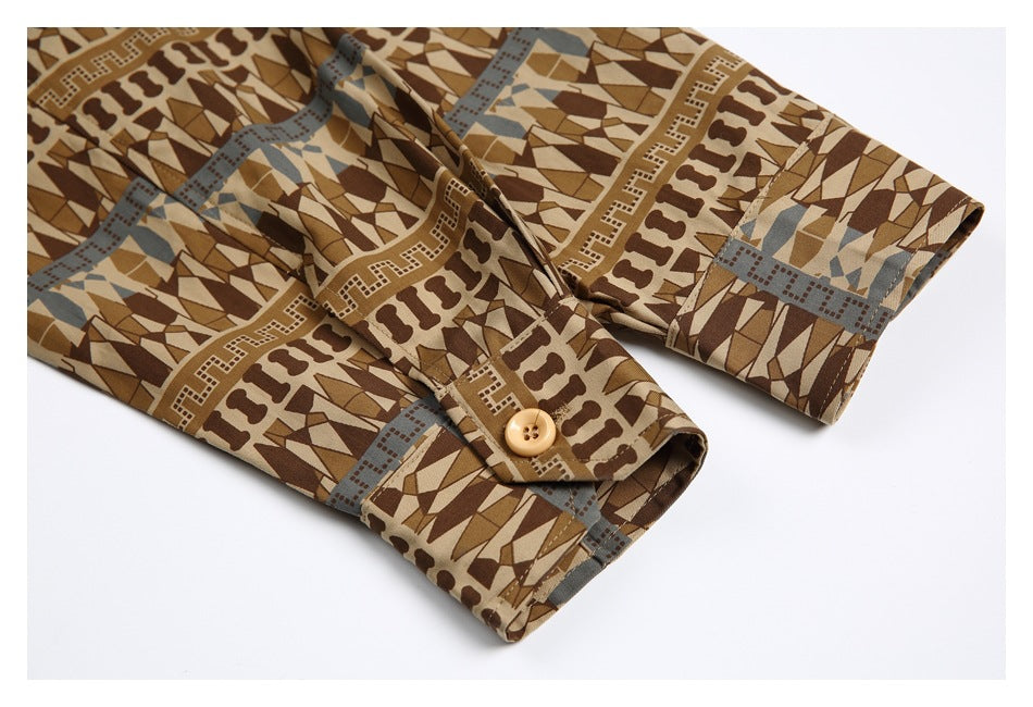 Close-up of a brown geometric-print shirt sleeve with a buttoned cuff.