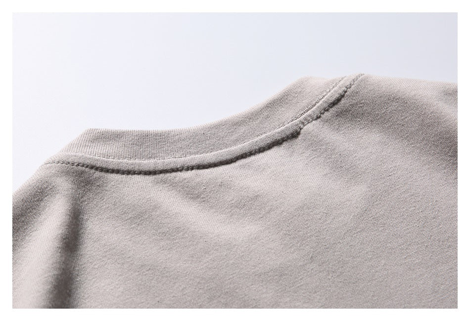 Close-up of the taupe-gray T-shirt neckline and stitched collar seam.