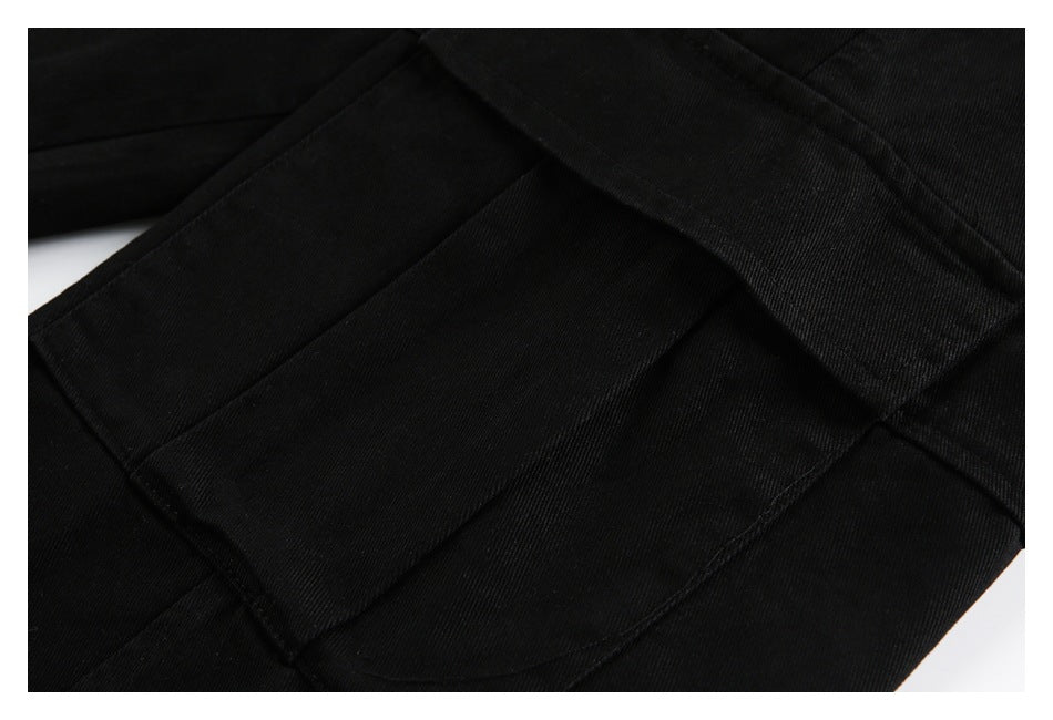 Close-up of black trouser fabric and stitched panel seams.