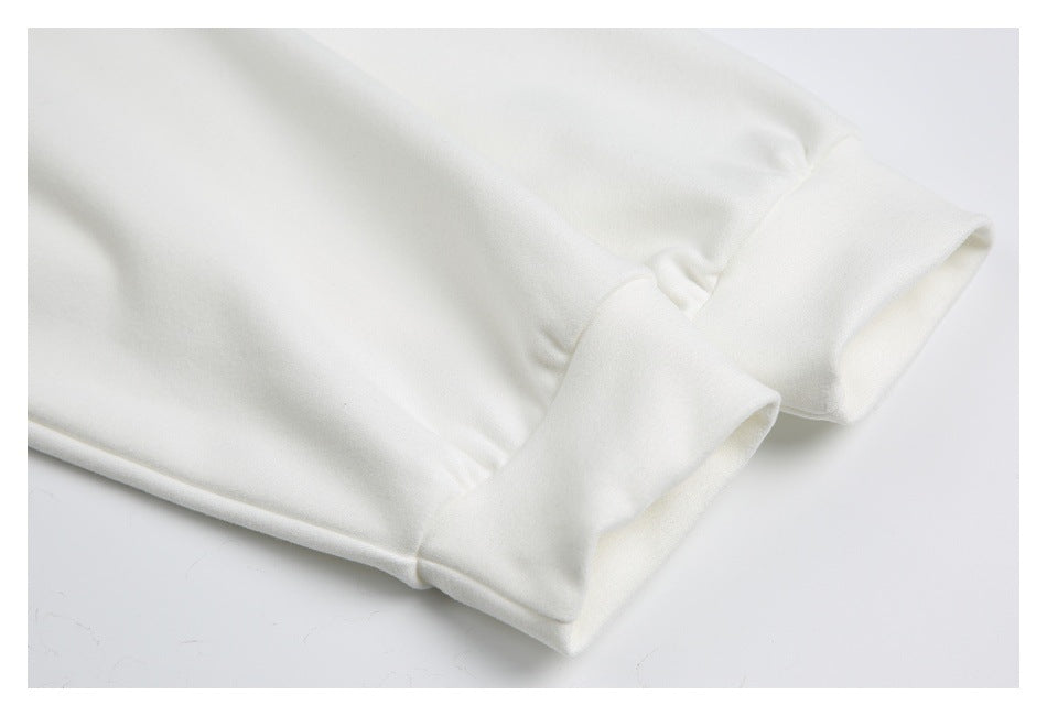 Close-up of a wide folded cuff and stitching on white fabric.