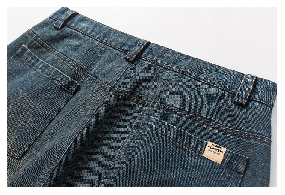 Angled close-up of the back waistband and pockets of blue faded jeans, with belt loops and a small sewn label.