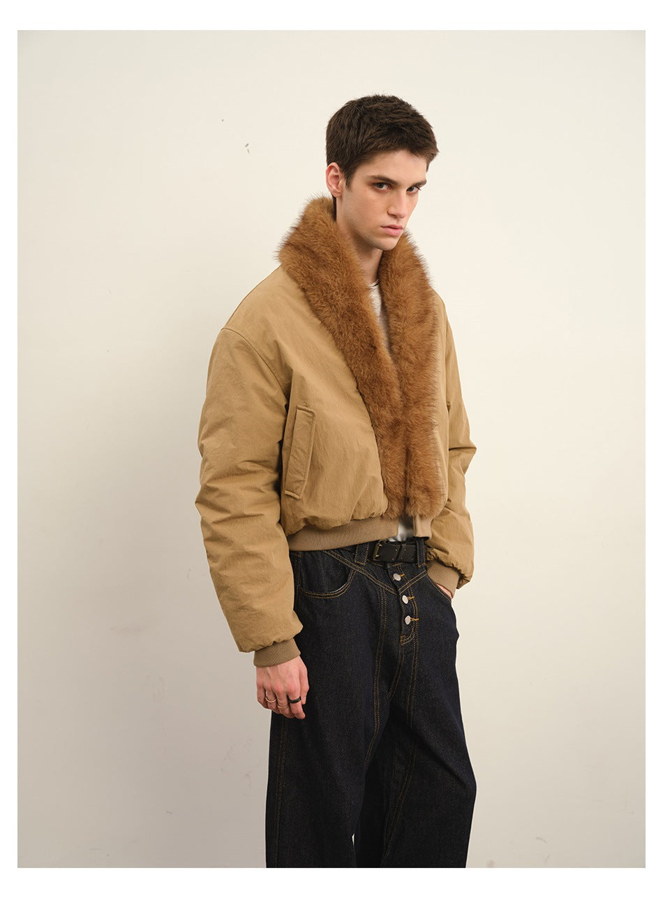 Three-quarter view of a model wearing a tan bomber jacket with a plush brown collar and dark jeans.