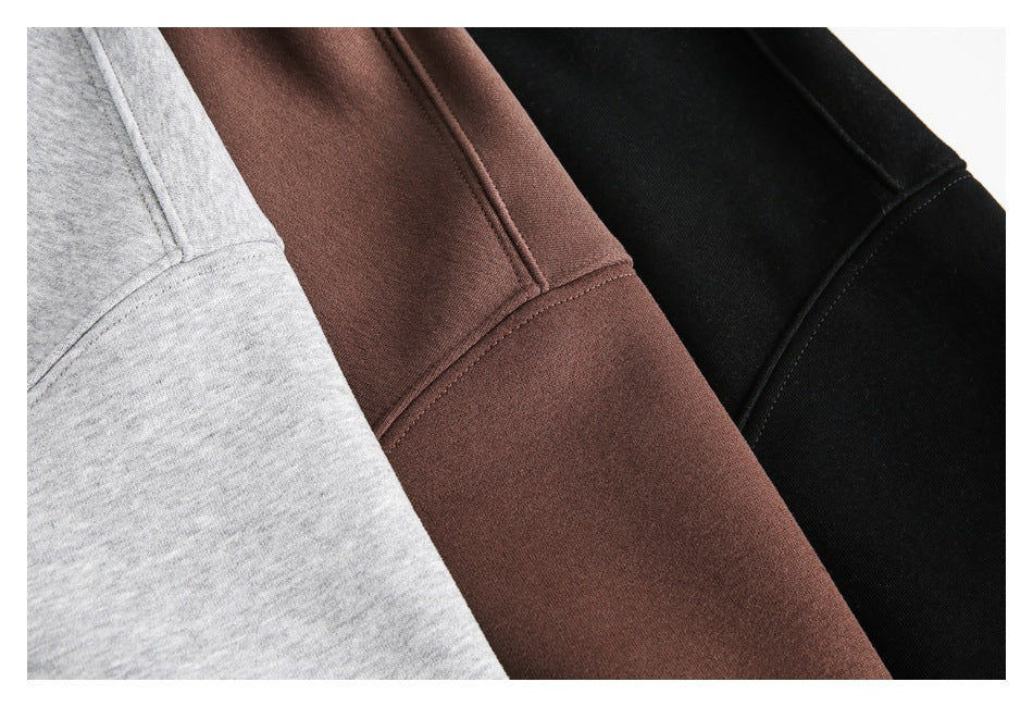 Close-up detail of stitching and fabric on gray, brown, and black hoodies.