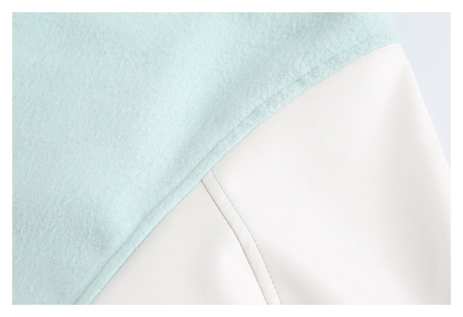 Close-up of mint and white garment panels meeting at a stitched seam.