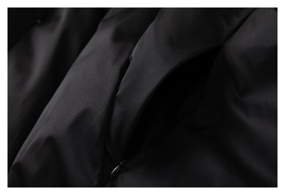 Close-up of a slanted zip pocket on the black jacket.