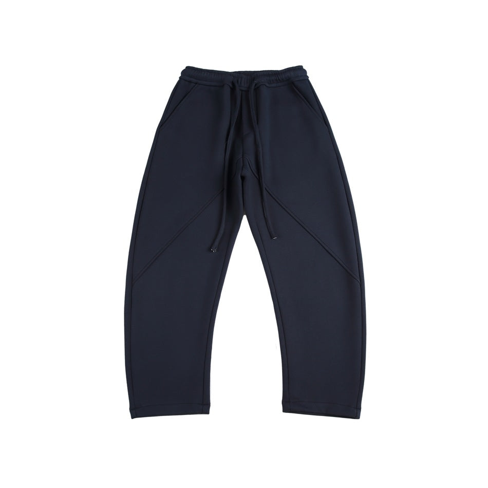Navy blue drawstring sweatpants with slanted pockets and diagonal front seams, flat lay, front view