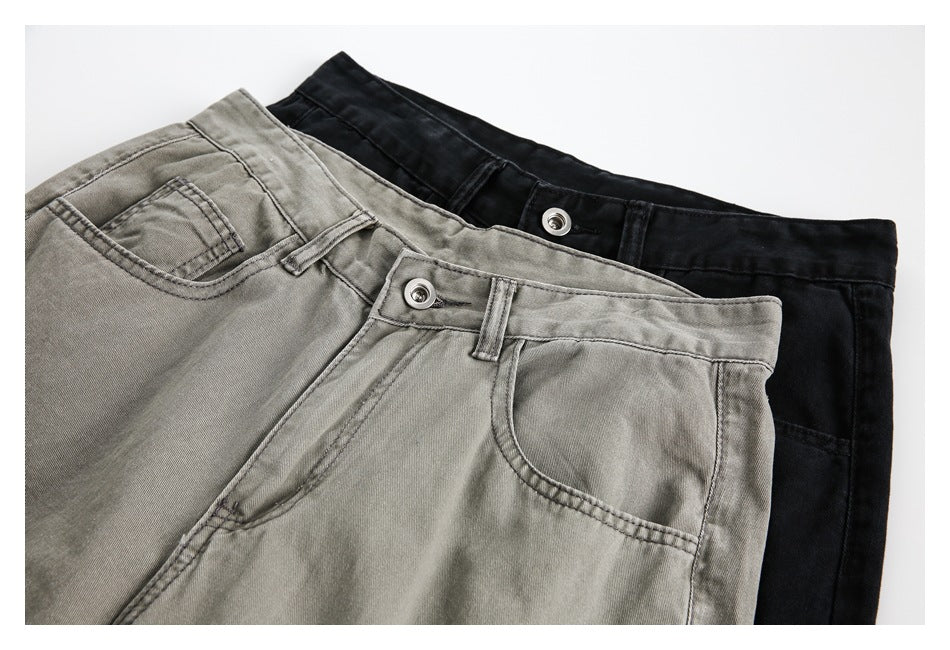 Close-up of gray and black cargo pants showing waistbands, buttons, belt loops, and front pockets.