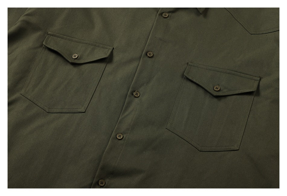 Close-up of an olive-green button-front shirt with two flap chest pockets and matching buttons.