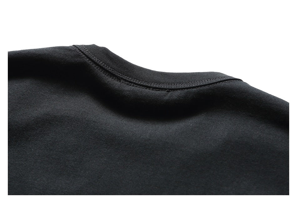 Close-up of the black T-shirt crew neckline and ribbed collar stitching.