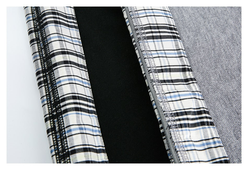 Close-up of gray garment fabric beside black, white, and blue plaid lining and overlocked seams.