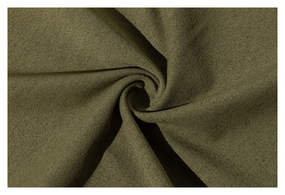 Close-up of olive-green fabric gathered into folds, showing its surface texture.