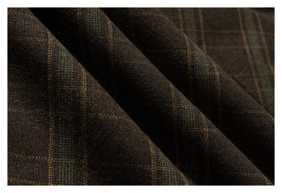 Macro view of dark brown plaid fabric with muted tan and green windowpane lines.