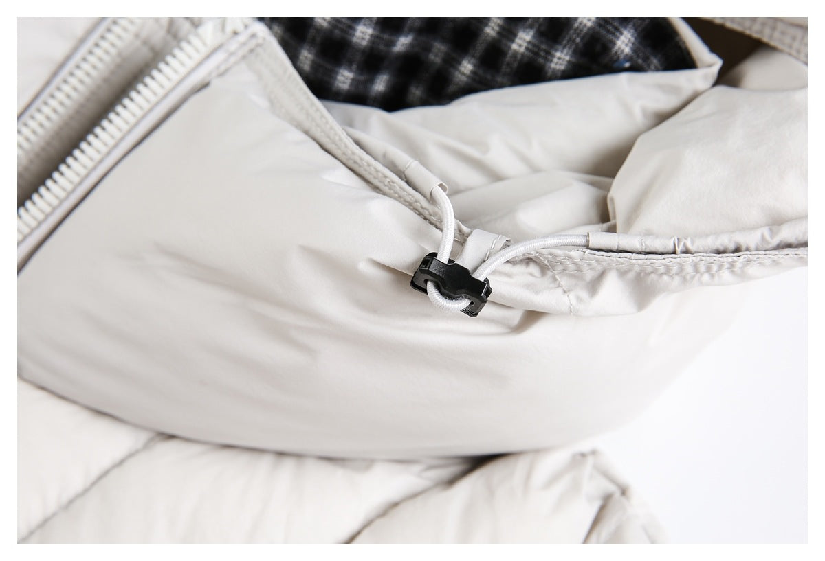 Close-up of an off-white jacket hood's adjustable drawcord and black toggle.