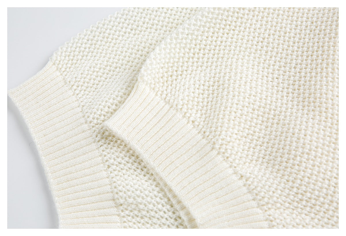 Close-up of the ivory sweater's ribbed cuff and textured knit sleeve.