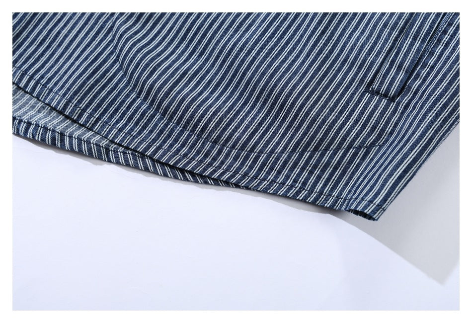 Close-up of the curved stitched hem on navy-and-white pinstriped fabric.