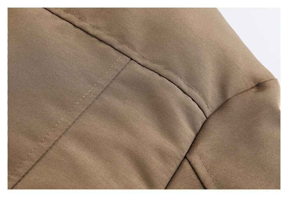Close-up of brown garment fabric and intersecting stitched seams.