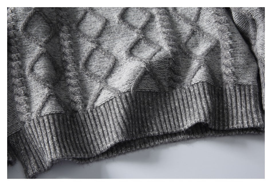 Close-up of the gray sweater's textured knit pattern and wide ribbed hem.