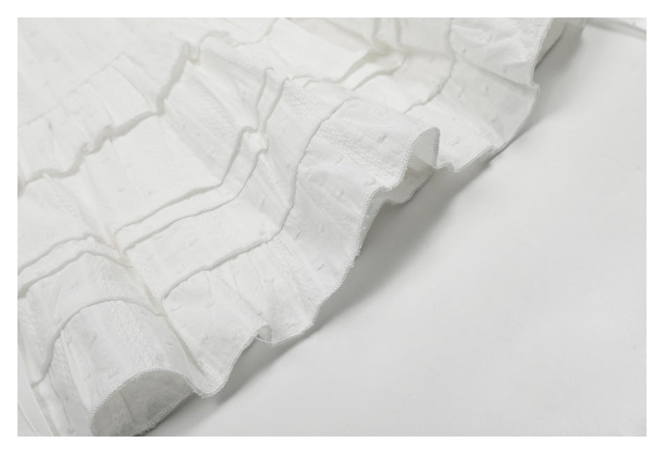 Close-up of the layered ruffled hem and raised texture on a white skirt.