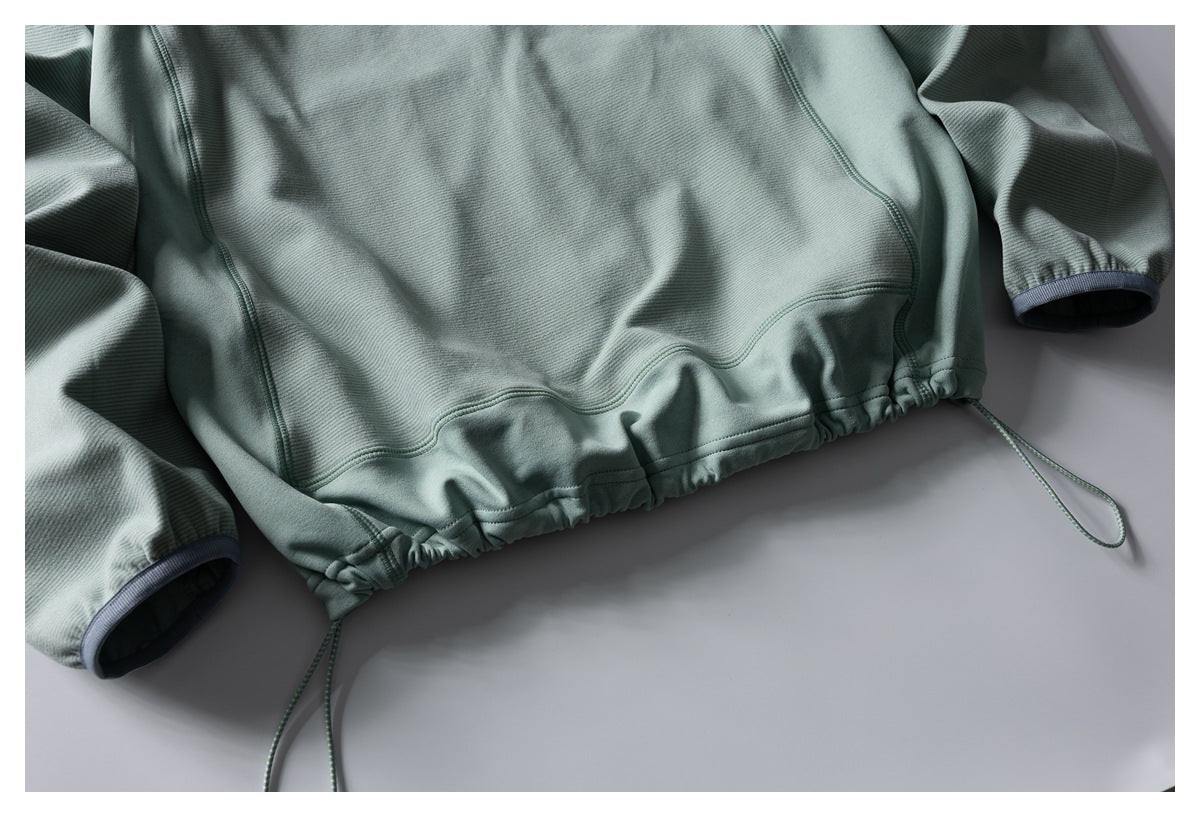 Sage-green long-sleeved pullover laid flat, with a gathered drawcord hem and dark-trimmed cuffs.