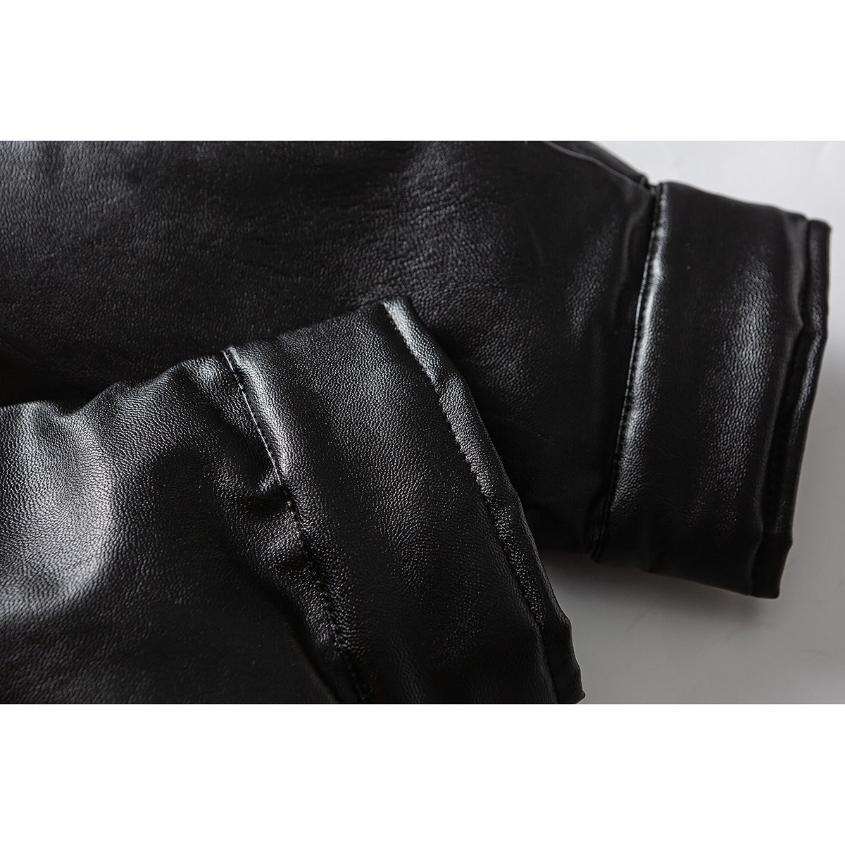 Close-up of the black jacket sleeve and cuff with visible seams and folded fabric.