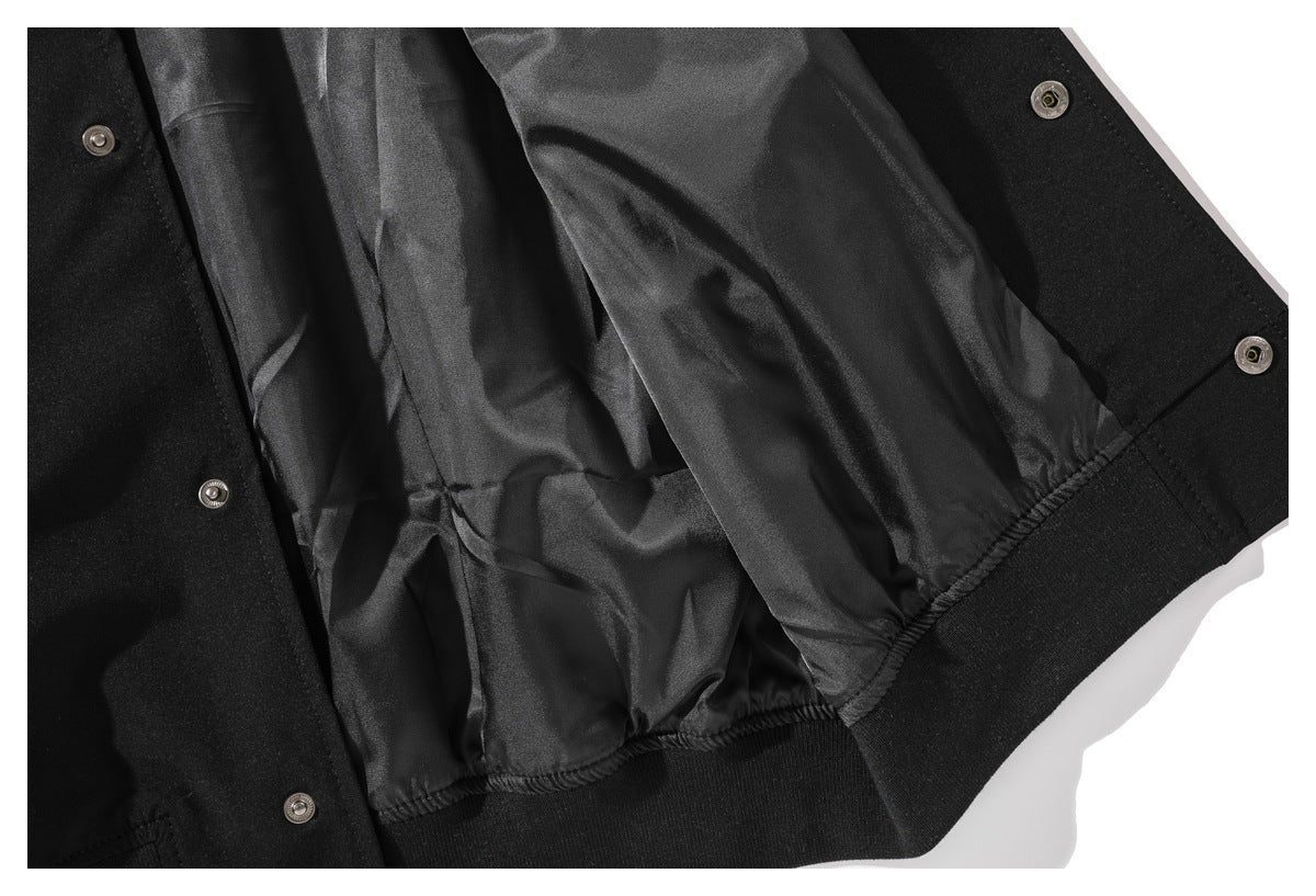 Close-up of the black jacket's shiny inner lining, snap fasteners, and ribbed hem.