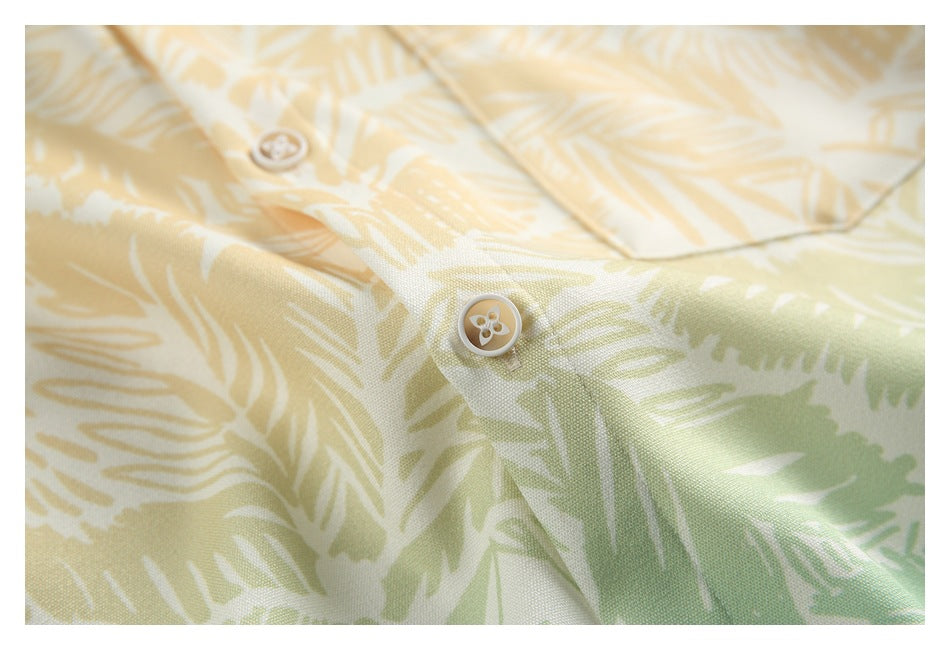Close-up of buttons and leafy print on cream shirt fabric, with pale yellow and light green accents.