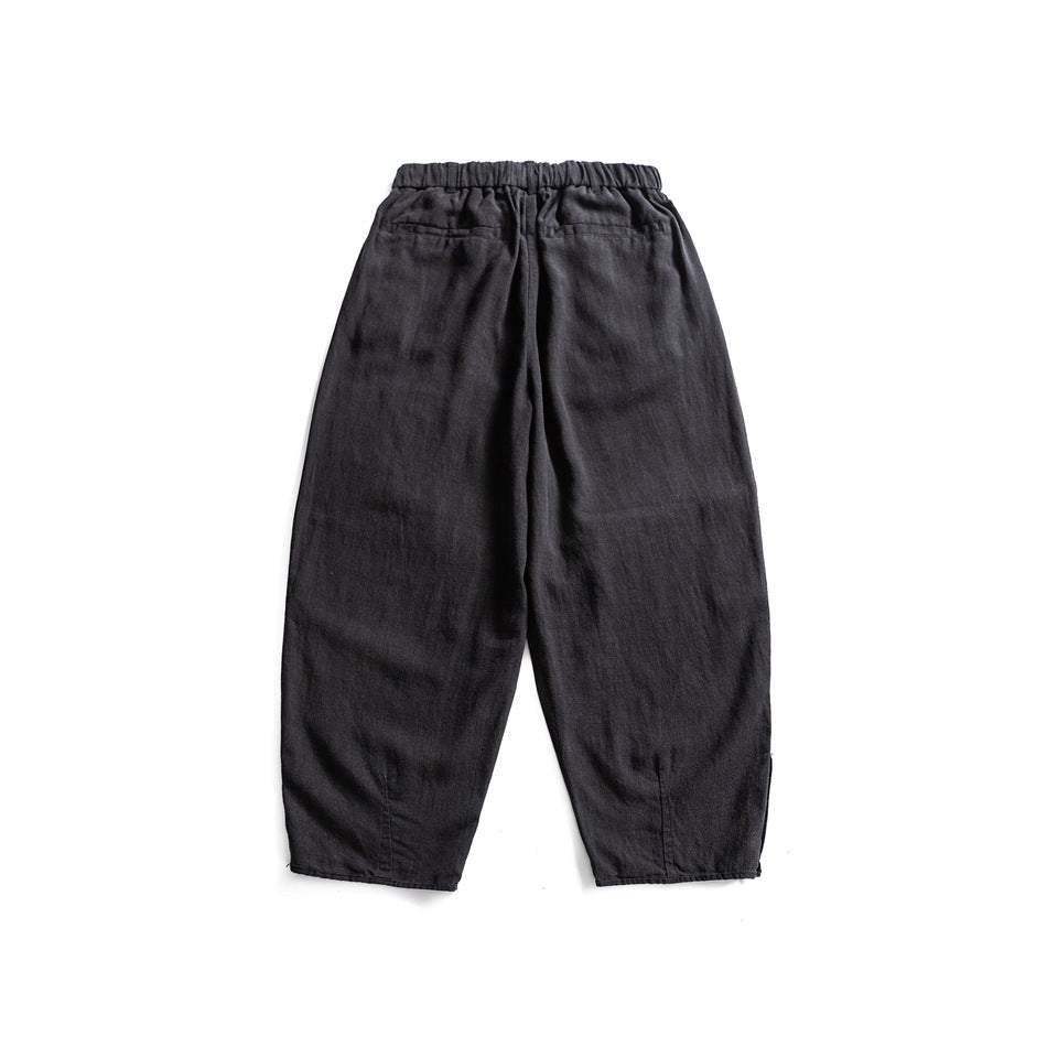 Back view of black relaxed trousers with an elastic waistband and two rear pockets.