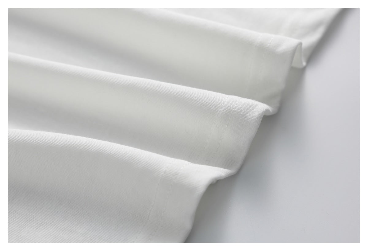 Close-up of a white garment's folded, double-stitched edge.