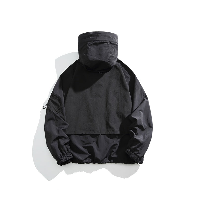 Back view of a black hooded jacket with a large rear panel and elastic cuffs and hem.