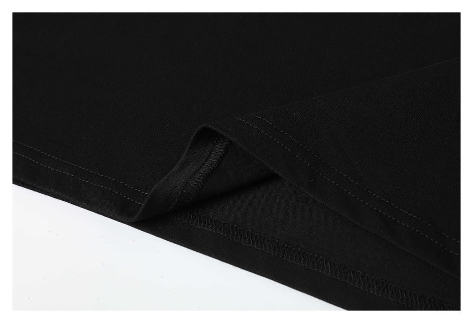 Close-up of the black T-shirt's folded lower hem and interior overlock stitching.