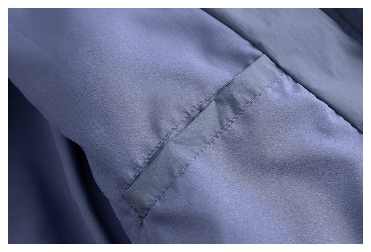 Close-up of a blue-gray jacket seam and stitched fabric panel.