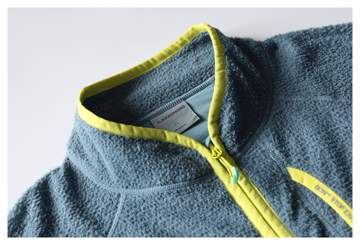 Close-up of a blue textured fleece jacket collar with bright yellow-green trim, a front zipper, and an inner label.