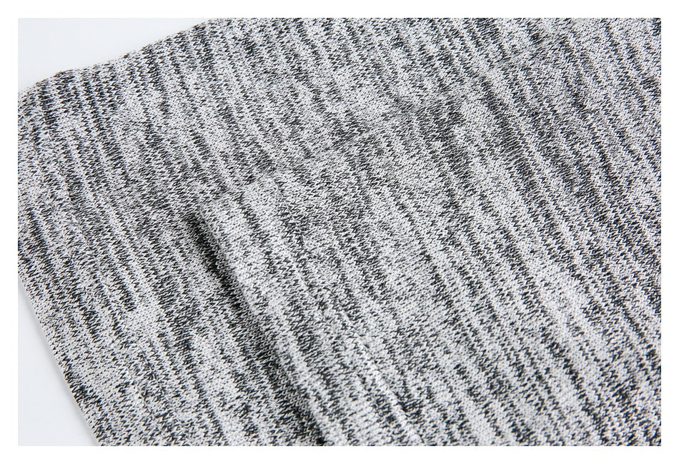 Close-up of a folded, stitched edge on black, gray, and white marled knit fabric.