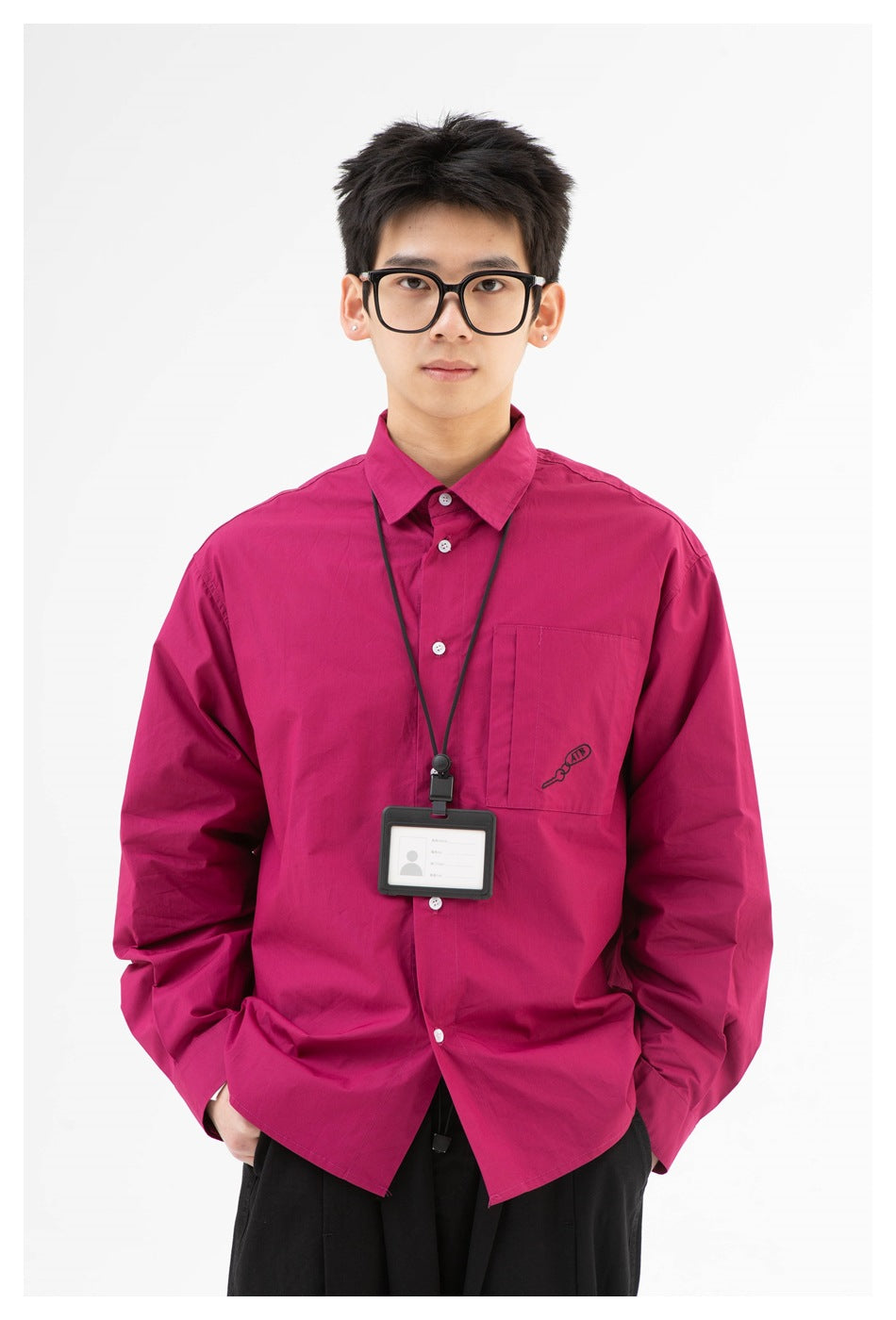 Model wearing a bright magenta button-up shirt with a chest pocket and black lanyard against a white background.