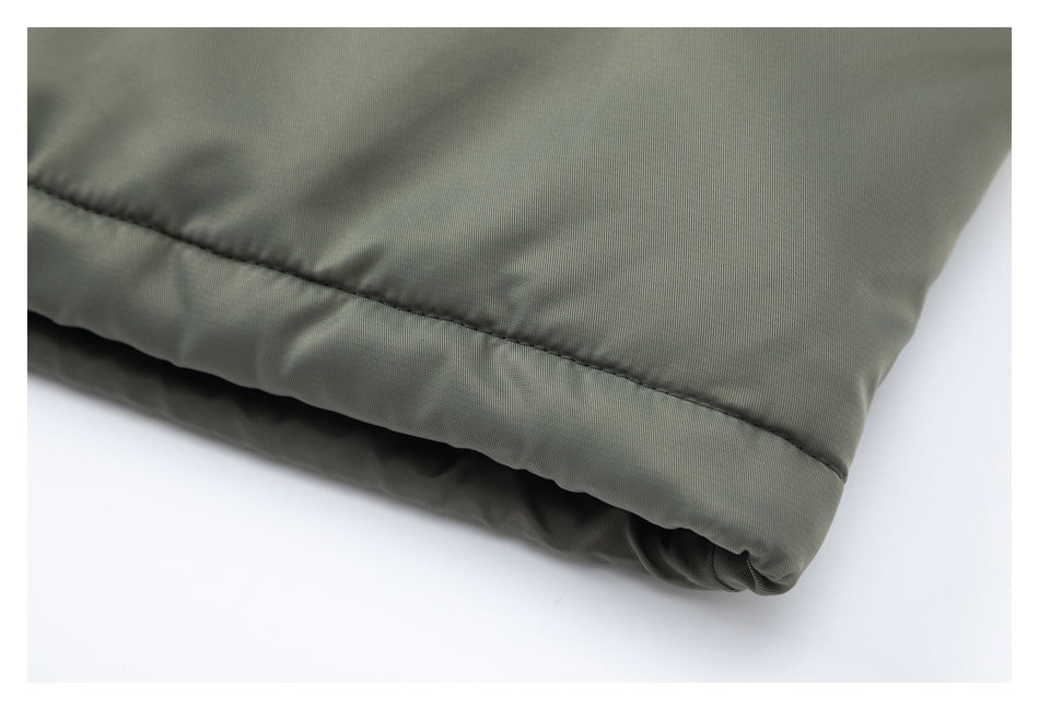 Close-up of an olive-gray garment hem with visible stitching and a folded edge.