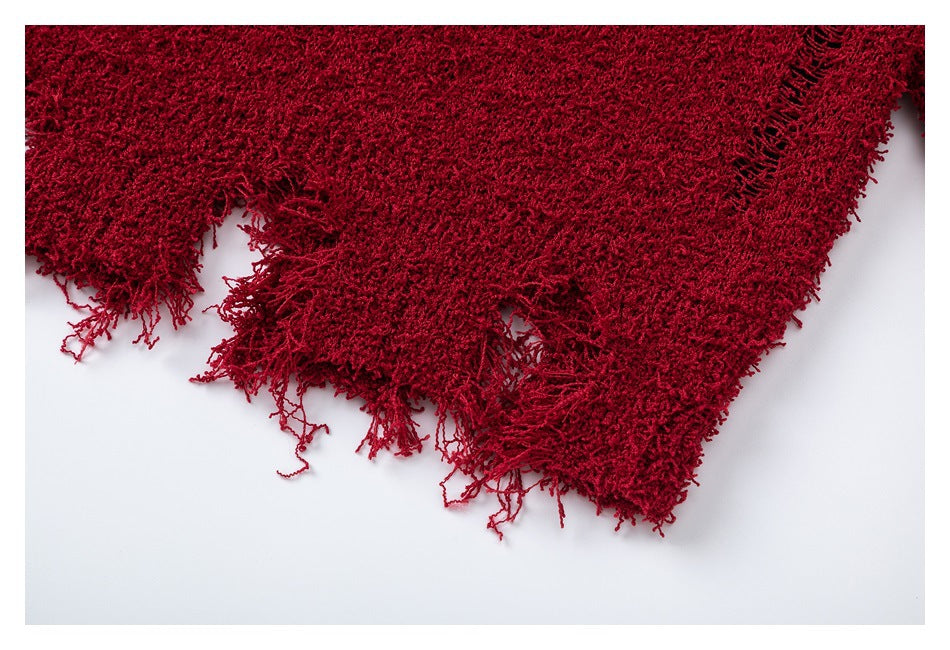Close-up of the red scarf's shaggy weave and loose fringe along its edge.