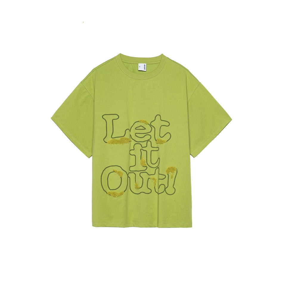 Light green short-sleeve t-shirt with dark green 'Let it Out!' outline lettering and yellow-green textured patches on the