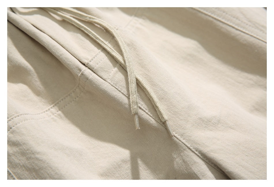 Close-up of the beige pants' drawstring, waistband stitching and fabric.