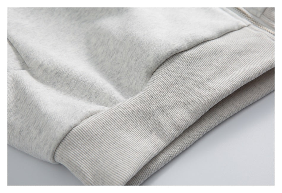 Close-up of a wide ribbed hem on a light gray heathered garment.