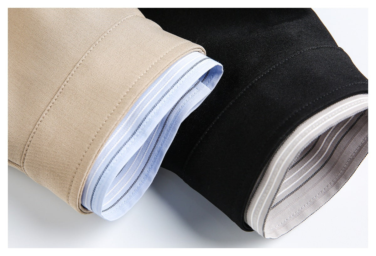 Close-up of beige and black jacket cuffs with light blue striped shirt cuffs showing underneath.